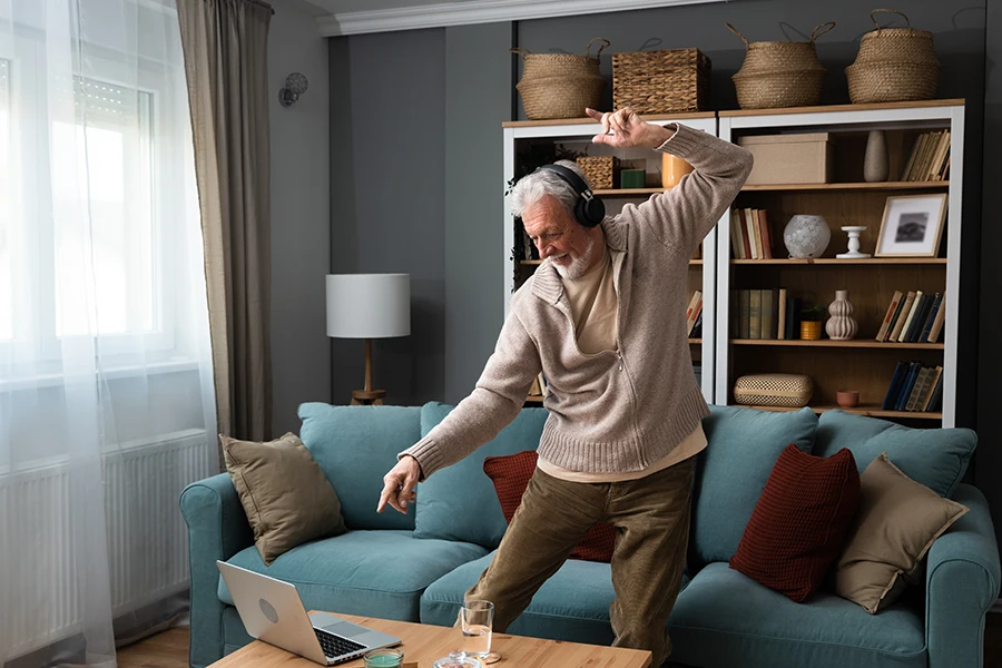 Older man dancing in front of a laptop