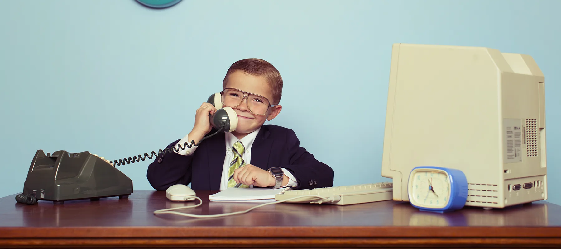 Homage to a vintage office setup with a child in a suit on the phone